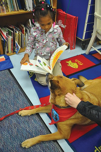 Jasmine Beechy, a first-grader in Deb ZandersÃ¢â‚¬â„¢ class, reads Ã¢â‚¬Å“The Very Hungry CaterpillarÃ¢â‚¬Â to Allie, an 8-year-old mixed-breed dog certified through Therapy Dogs International.