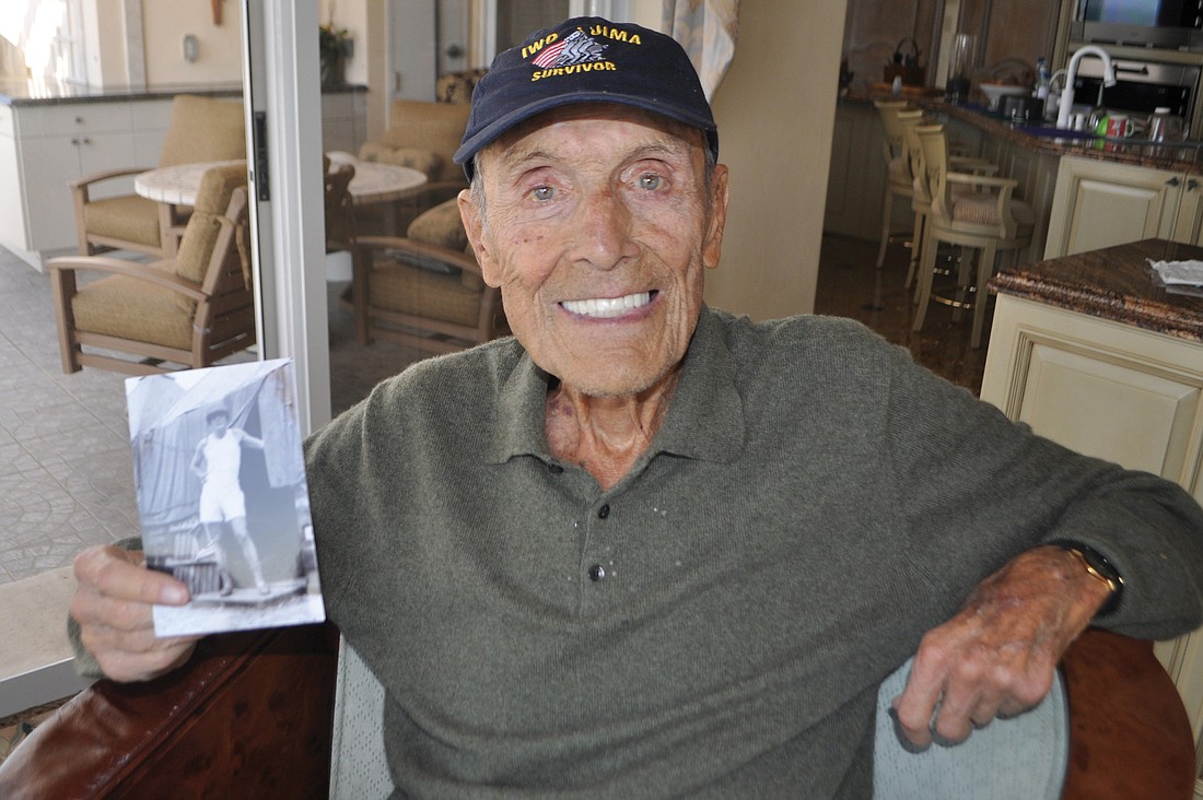 Marty Samowitz, 98, holds a photo of himself at age 27, shortly after he joined the Air Force.