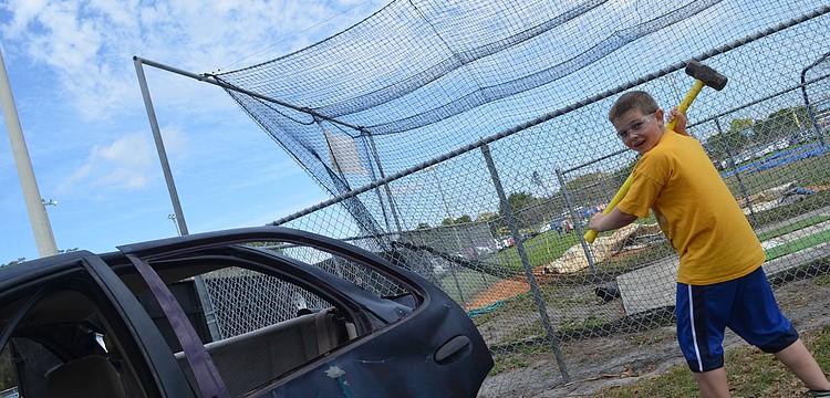 Dru Cappar, 9, smashes a car with a sledgehammer at one of the festival games.