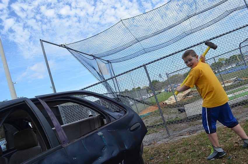 Dru Cappar, 9, smashes a car with a sledgehammer at one of the festival games.