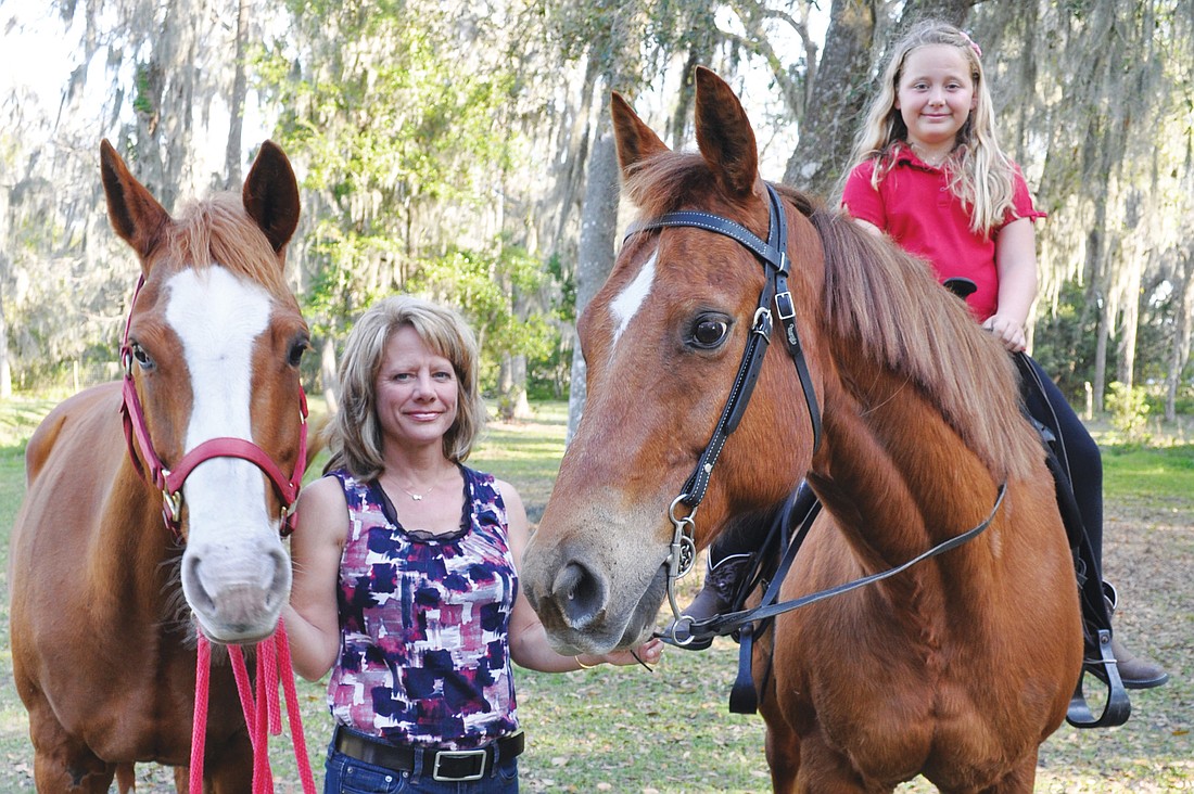 Stephanie Lloyd, leading Katy, and her daughter, Cassie, on Baxter