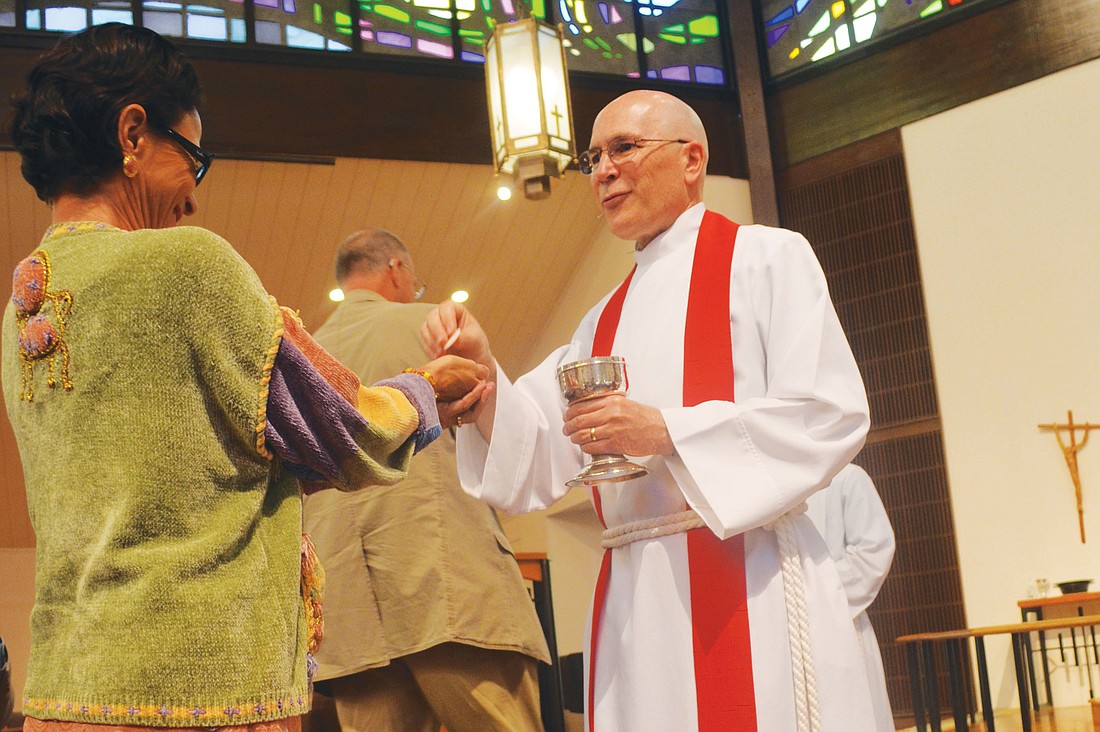 The Rev. John C. N. Hall gives out communion to parishioners at his installation Saturday, Feb. 23. "In these first few months one word that captures the job for me is 'vision,'" Hall says. Photos by Yaryna Klimchak