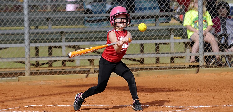 Seven-year-old Erin McIntyre makes contact during her team's season-opener versus Pemco Feb. 23.