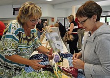 Suzanne Boissonneault shows her hand towels to Diane Grenier.