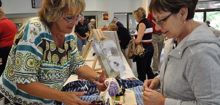 Suzanne Boissonneault shows her hand towels to Diane Grenier.