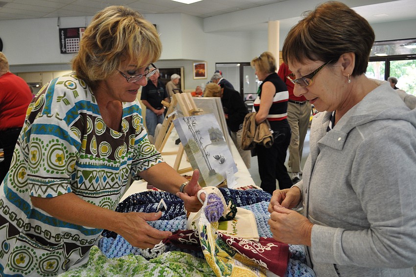 Suzanne Boissonneault shows her hand towels to Diane Grenier.