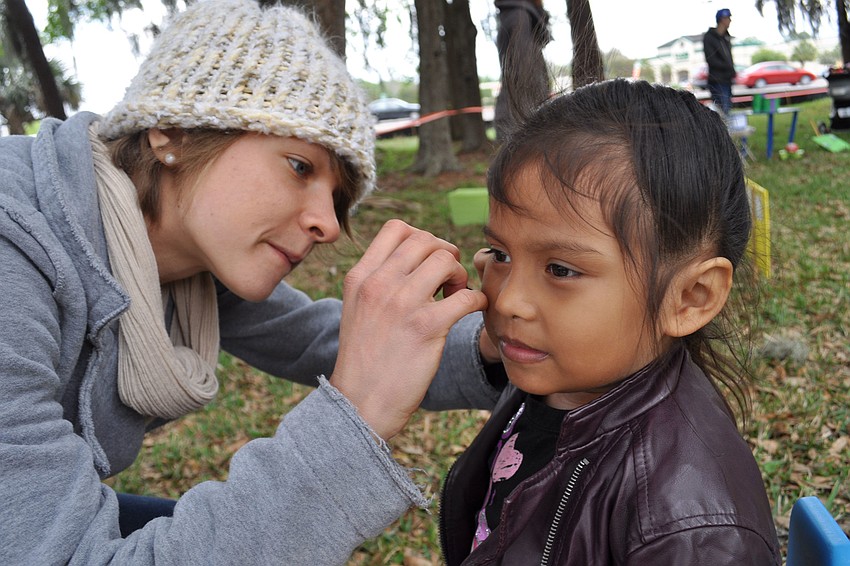 Danielle Buncik painted a yellow butterfly on the face of 4-year-old Abygail Jimenez.