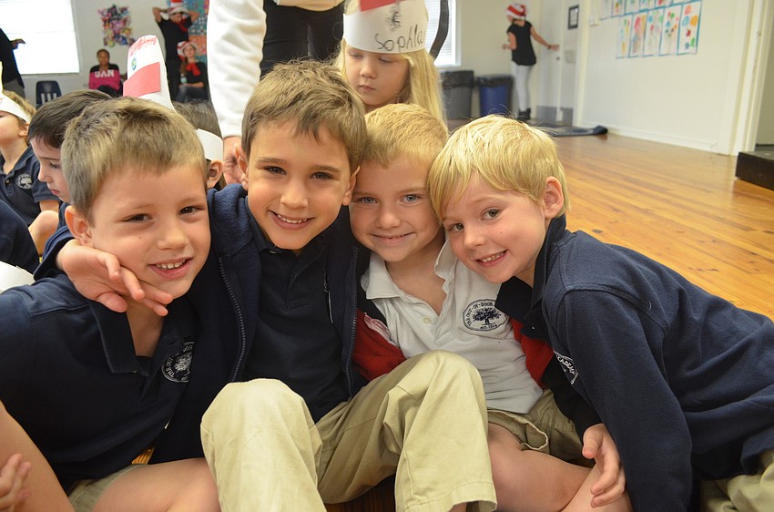 James, Alexander and Caleb listen to the seniors read a Dr. Seuss story.