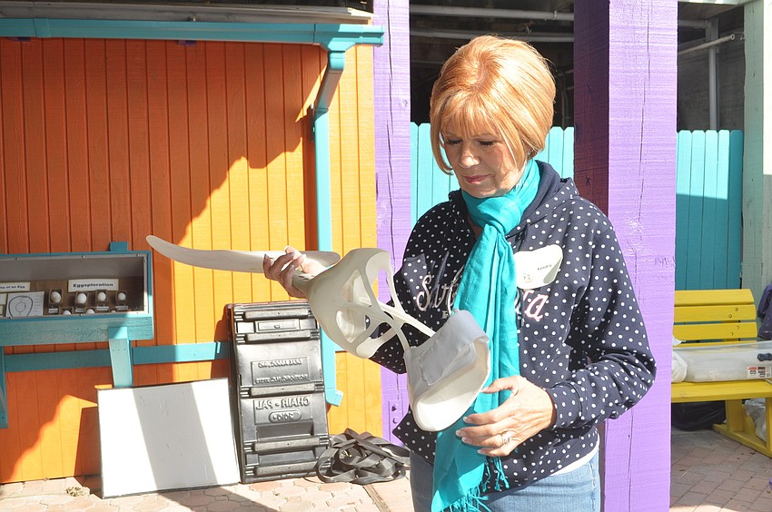 Kendra Cross, a new Save Our Seabirds volunteer, examines Winterâ€™s prosthetic tail.