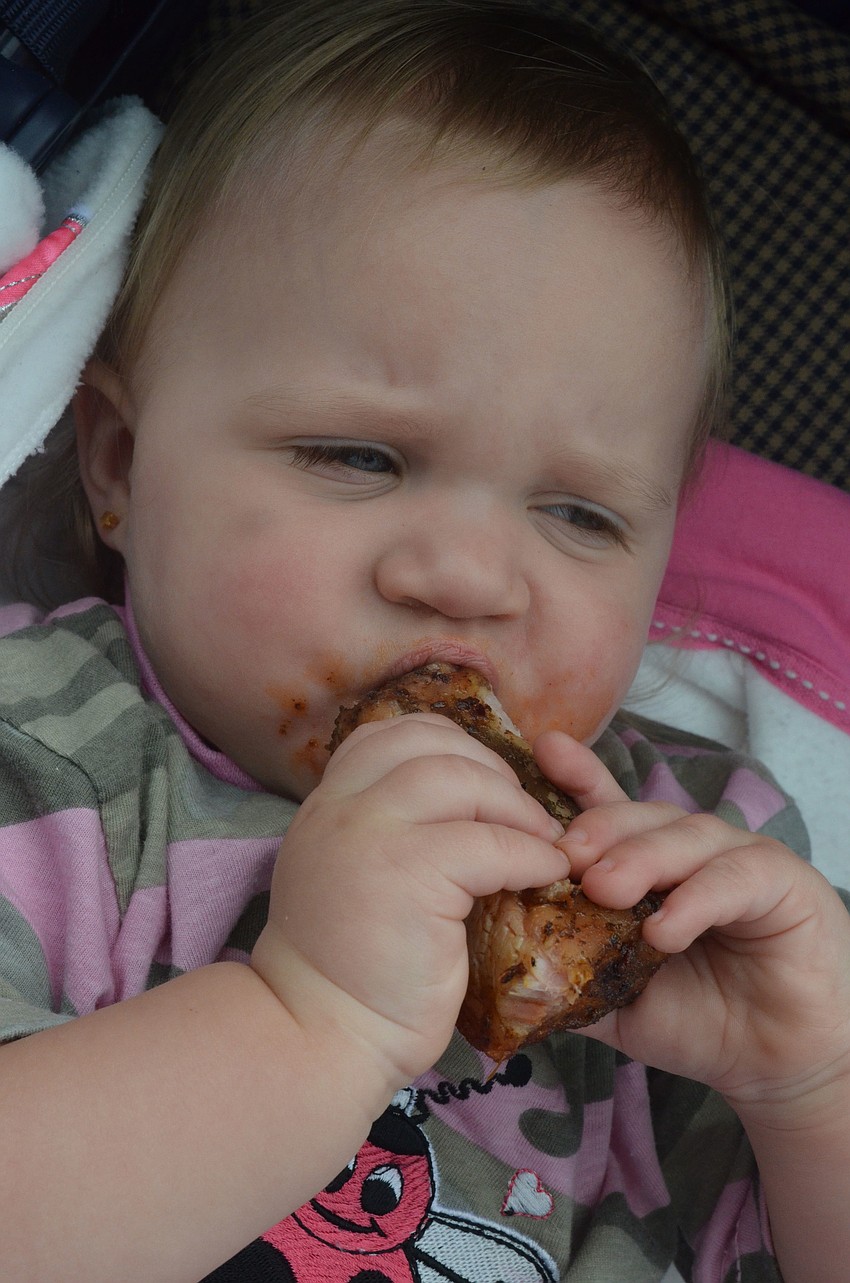 Annnabelle Bailey, 15 months, sucks on a barbeque rib.