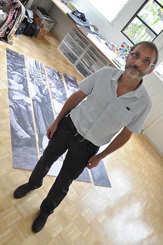 Wojtek Sawa stands in front of four of the large-scale photographs he will use in "The Wall Speaks" installation.