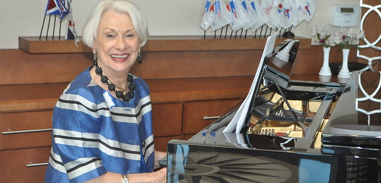Margaret Guthman plays Broadway tunes as models stroll through the dining room.