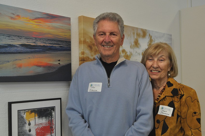 Ron and Jinny Johnson pose with Ronâ€™s sunset photo taken from his backyard.