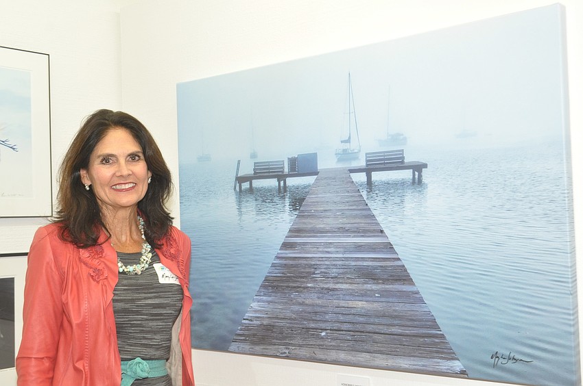 Mary Lou Johnson poses with her photo of the dock at MarVista.