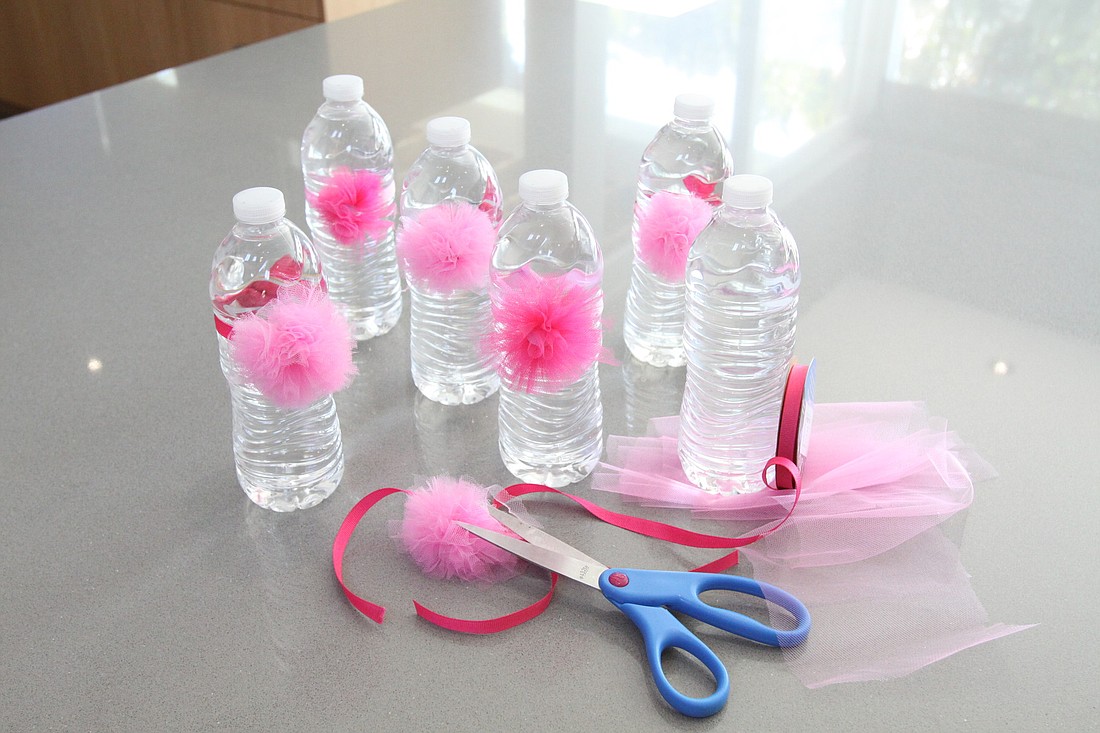  Learn to make festive water bottles for occasions such as a baby shower or a little girl's birthday party with ribbon and tulle pom-poms.