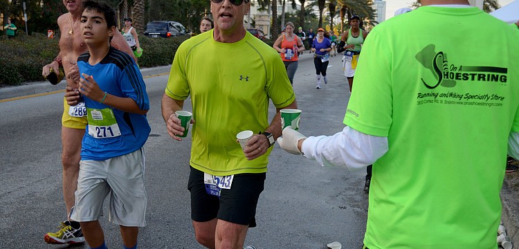 Runners stop for water near the six-mile mark.