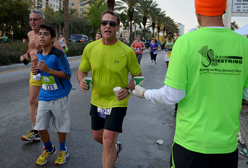 Runners stop for water near the six-mile mark.