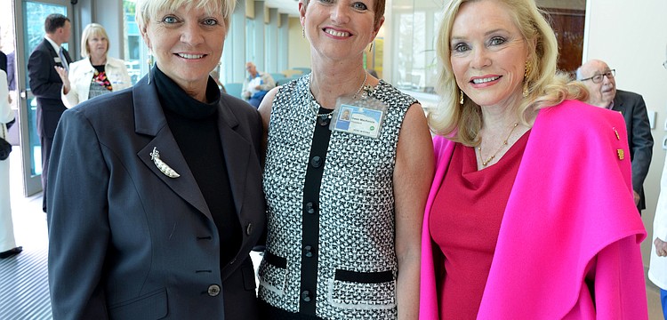 Alex Quarles, Gwen MacKenzie and Margaret Wise stand near the donor wall.