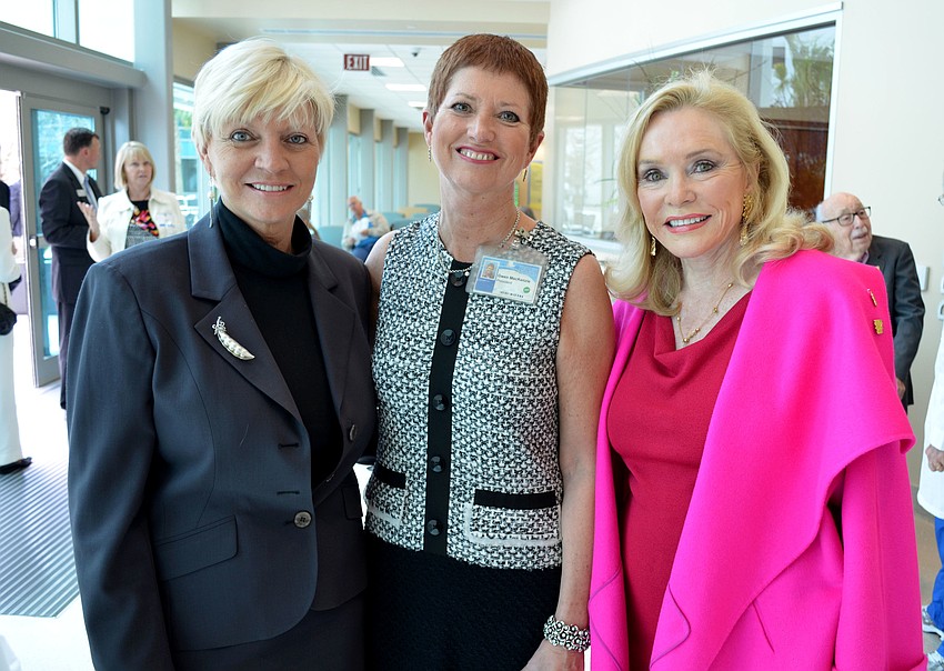 Alex Quarles, Gwen MacKenzie and Margaret Wise stand near the donor wall.