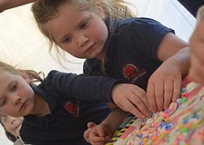 Marmalade Salon and Boutique staff member Jenna Dilorenzo and owner Nikki Mayforth help Ava Custer and Fallon Rossano make seashell necklaces.