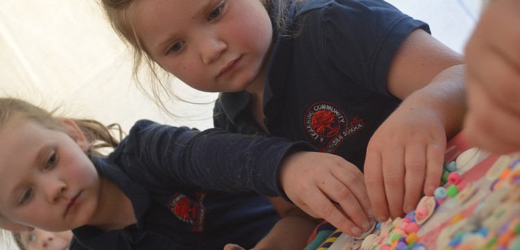 Marmalade Salon and Boutique staff member Jenna Dilorenzo and owner Nikki Mayforth help Ava Custer and Fallon Rossano make seashell necklaces.