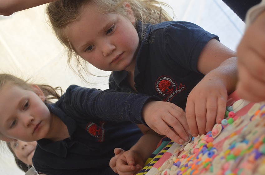 Marmalade Salon and Boutique staff member Jenna Dilorenzo and owner Nikki Mayforth help Ava Custer and Fallon Rossano make seashell necklaces.