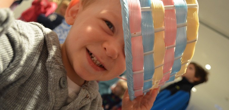 Colin Rudisell puts an Easter egg basket on his head during Granny Gooseâ€™s story time.