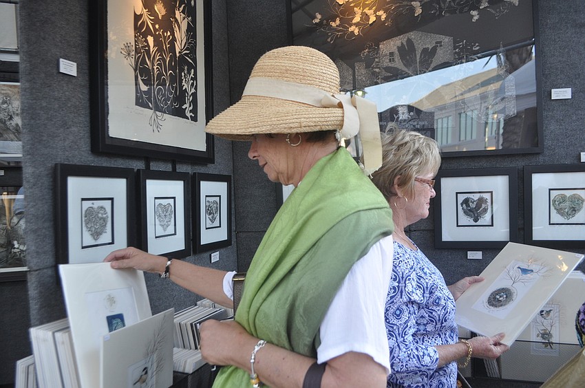 Karen Turner and Betty Anne Clary admire bird prints.