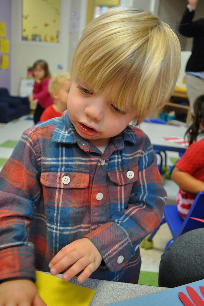 Sloan Mondor, 2, works on his hat.