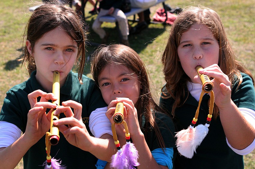 Ella Hess, 8, Isabella Swelland, 7, and Lauren Delknap, 7, have fun playing tunes on the flutes they bought at the festival.