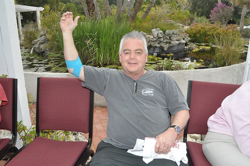 Bob McKone shows off his bandaged arm after giving blood.
