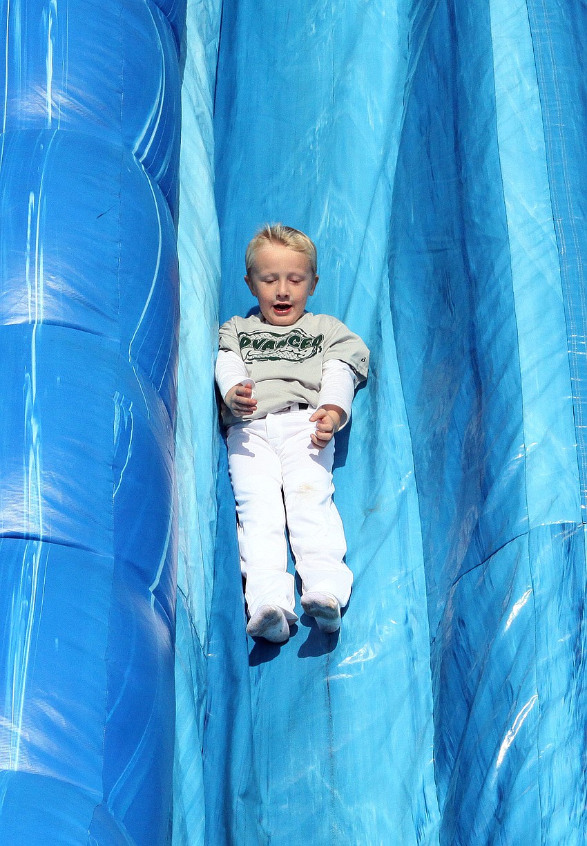 Stone Bass, 5, has fun sliding down an inflatable slide.
