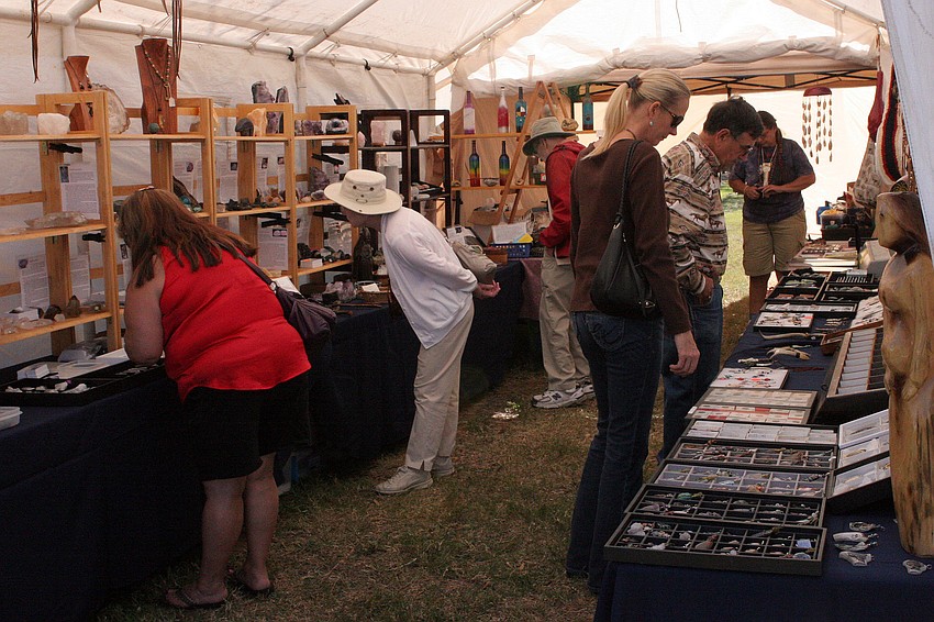 People browse the Native American dream catchers, stones, musical instruments and jewelry inside one of the many tents at the festival.