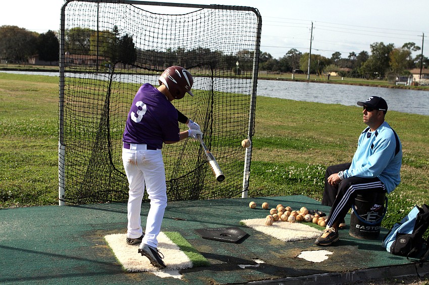 Stu Christensen throws balls for Jake Nash. 12, to hit during warm ups.