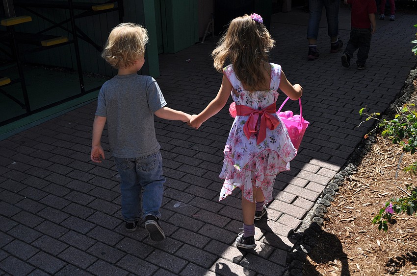 Raistlin, 4, and Kaylee, 6, Zerby run hand-in-hand down a path at Jungle Gardens.
