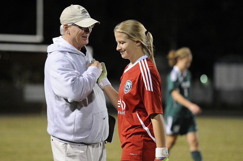 Lakewood Ranch assistant coach Jim Wojcicki congratulates goalkeeper Alex Latham on her 14th shutout of the season.