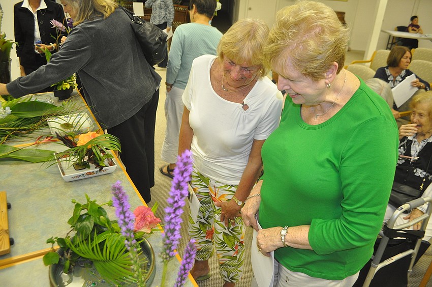 Joan Viguers and Loretta Conniff admire a slanting style arrangement.