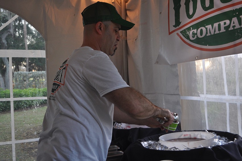 Scott Pastor, of Sarasota Yogurt Co., serves chocolate frozen yogurt.