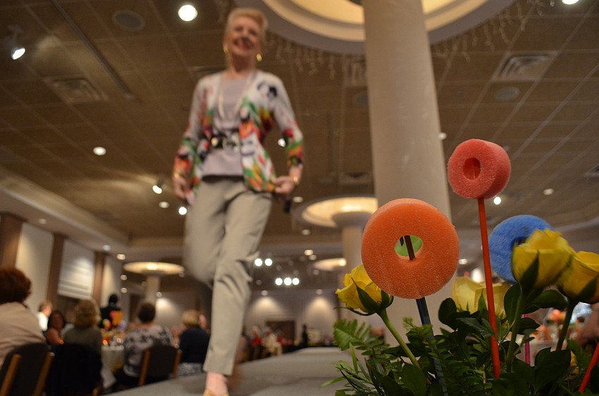Adrienne Wagner walks down the runway. The Sarasota Garden Club put together the centerpieces that adorned the runway and the tables.