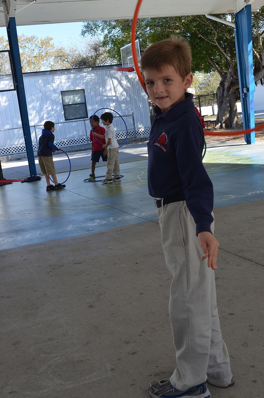 Kaes Verhagen, 7, demonstrates how to spin the hula hoop in his arm.