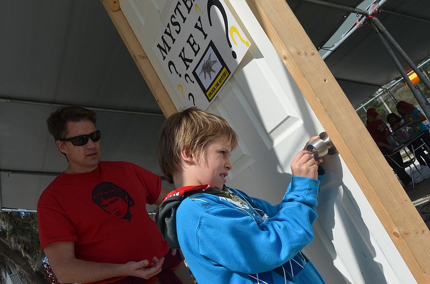 Eldon Johnson let children pick keys to try and unlock the mystery door. David Pfeil, 8, chose the correct key and got a prize.