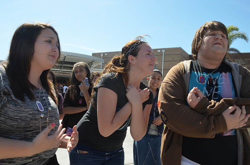 Sophomores Alexis Rutter, Rachel Rohn, and Brandon Thomas sing along to a pop song during the rally.