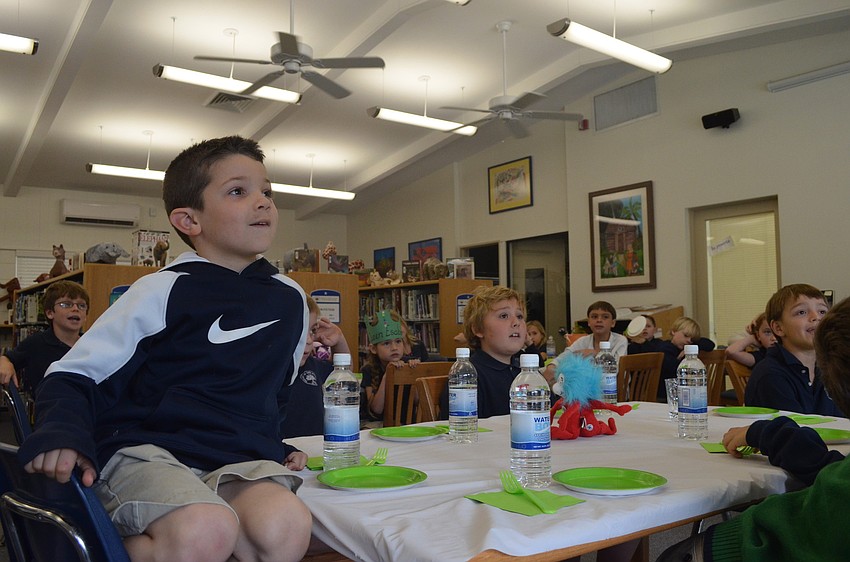 First grader Johnny listens intently to librarian Glendy Huene.