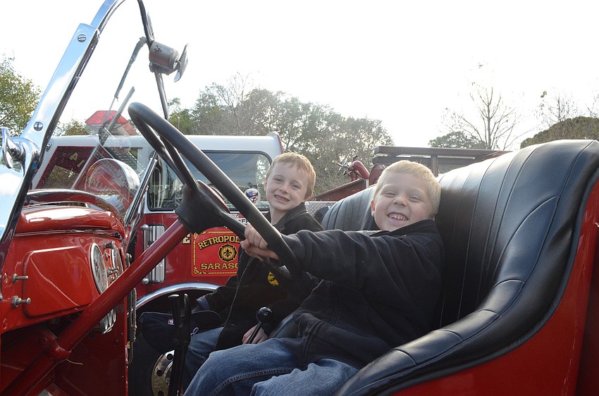 Cameron Azar, 7, climbs the vintage truck with his 5-year-old brother, Taj.