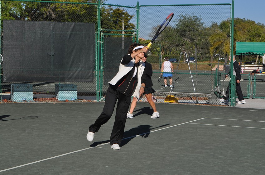 Barbara Egerstrom attempts a volley from the baseline.
