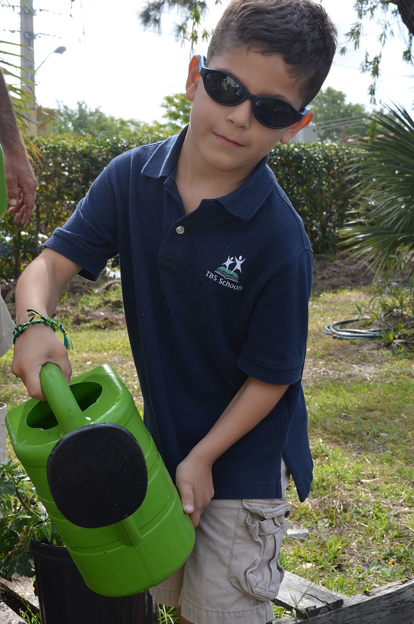 Tyler Ruben, 6, waters plants during recess.