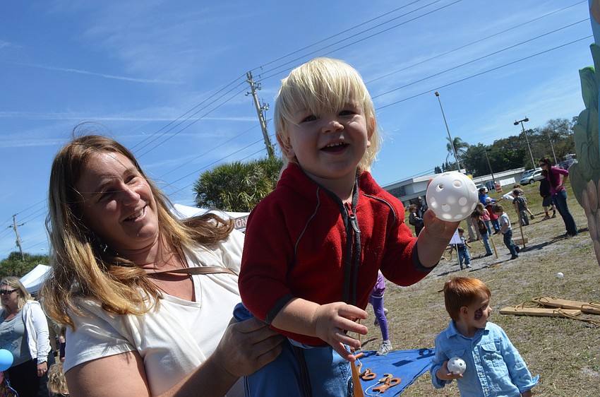 Heidi Dahlborg holds her son Toby, 2, as he throws a ball in Pinocchioâ€™s Land.