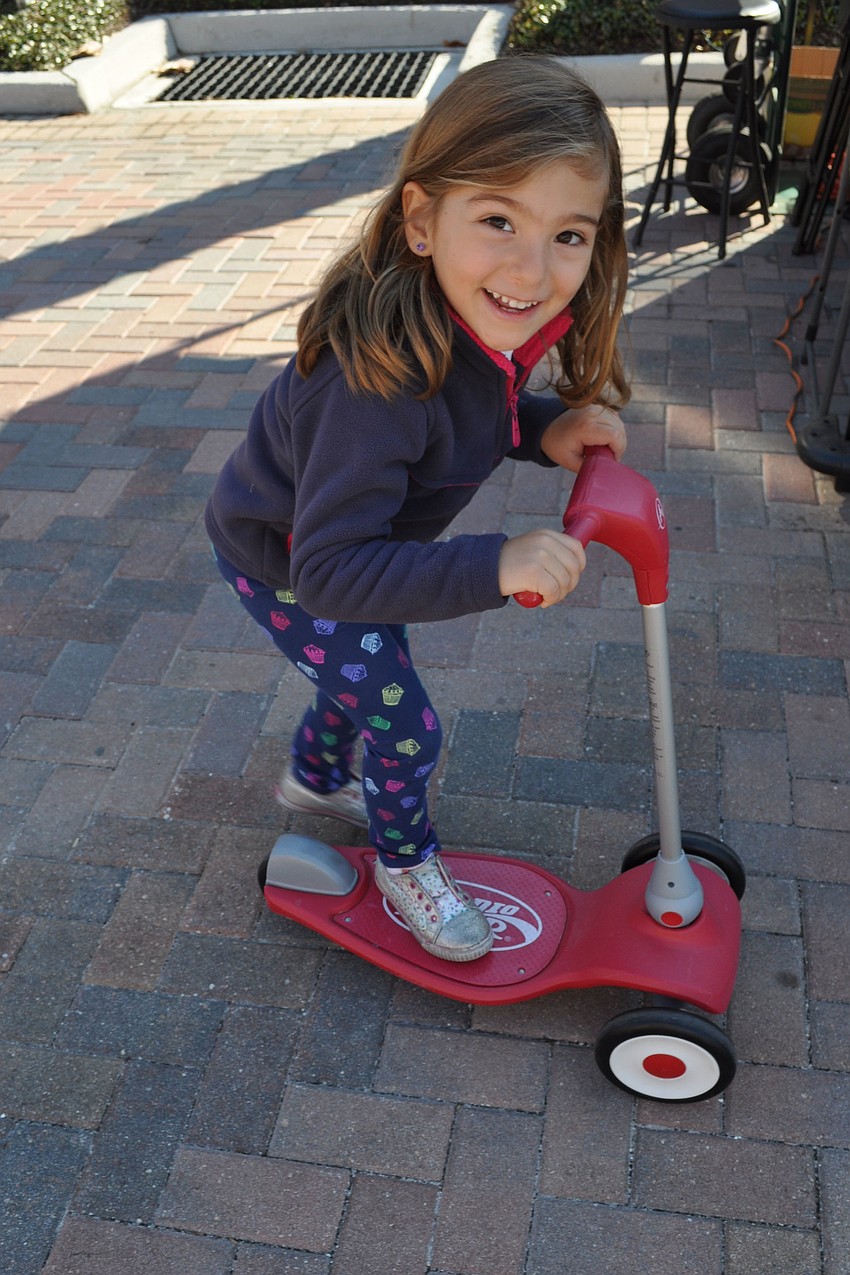 Lara Ajouzi, 4, rode in on her scooter.
