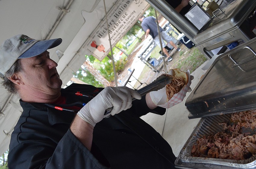 Mike Card, of Smoke Daddy BBQ, hands out pulled pork to attendees.