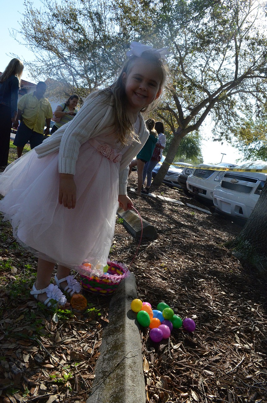 Ashleigh Morris picks up the eggs she accidentally dropped during the Easter egg hunt at St. Michael the Archangel Catholic Church.
